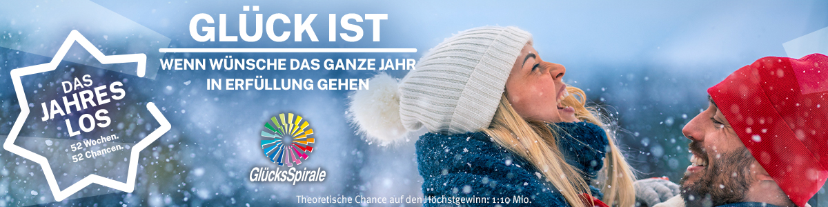 GlücksSpirale Jahreslos-Werbung mit lachendem Paar im Schnee und Slogan: Glück ist, wenn Wünsche das ganze Jahr in Erfüllung gehen.